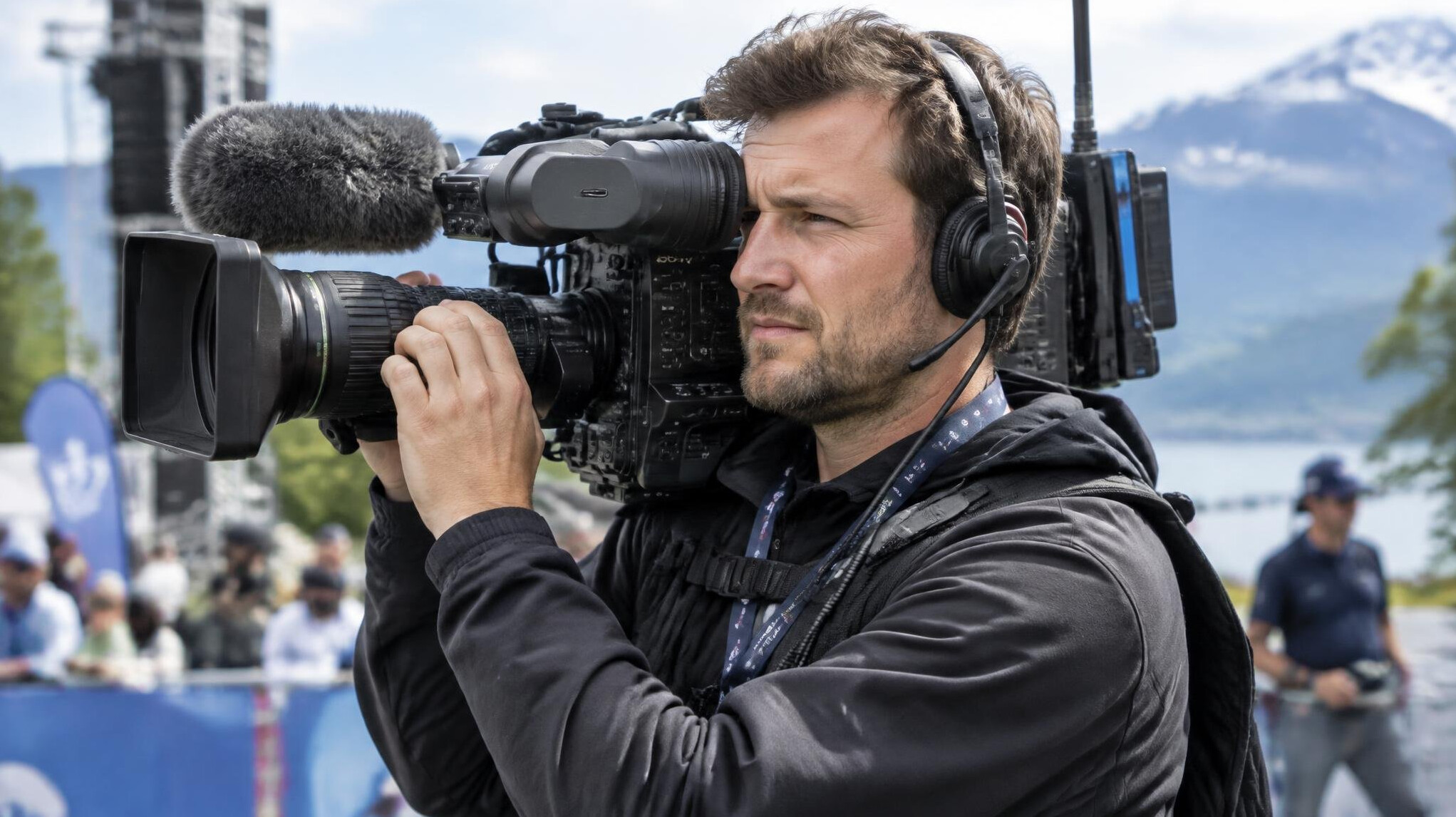 Cameraman filming with a shoulder-mounted professional camera